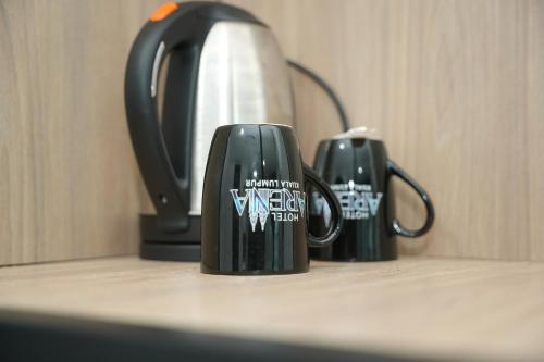 two black coffee mugs sitting on a counter at Arena Suites Kuala Lumpur in Kuala Lumpur