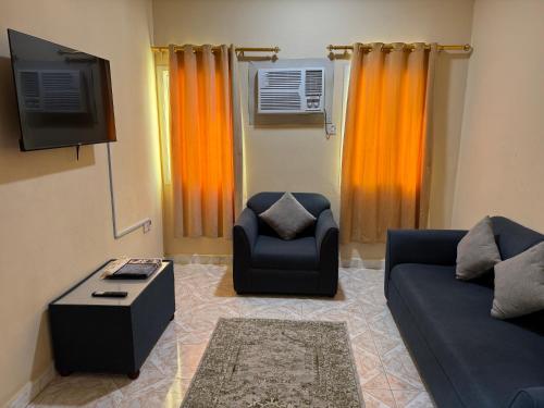een woonkamer met een bank en een stoel bij هومي Homi in Salalah