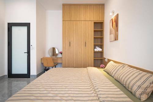 フエにあるDreams Homestay with Full Kitchen & Big Loungeのベッドルーム1室(大型ベッド1台、木製キャビネット付)