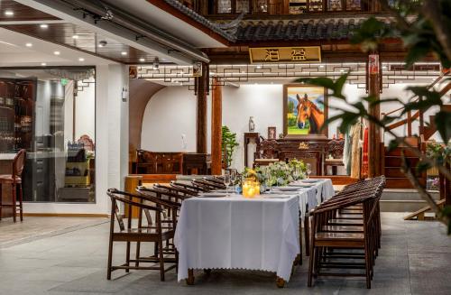 a dining room with a table with white table cloth at Boying happywin Guofeng Shangyuan Lijiang Ancient Town South Gate Store in Lijiang
