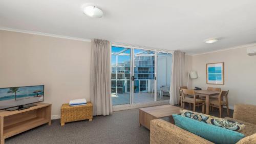 a living room with a couch and a television at Blue Ocean in Ettalong Beach