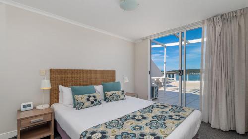 a bedroom with a bed and a view of the ocean at Blue Ocean in Ettalong Beach