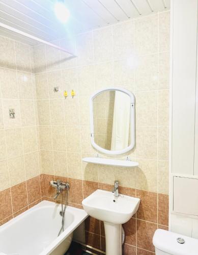 a bathroom with a sink and a toilet and a mirror at City Apartments in Oral