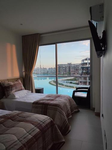 a hotel room with two beds and a large window at BAIA KRISTAL CARTAGENA Mi descanso ideal in Cartagena de Indias