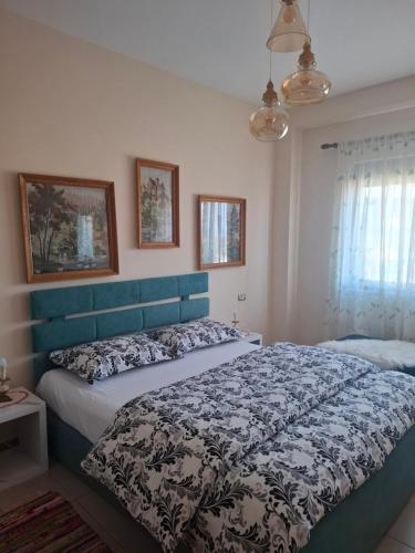 a bedroom with a large bed with a blue headboard at Panoramic apartment in Shkodër