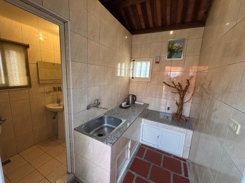 a small bathroom with a sink and a toilet at 八八古藝民宿可包棟 in Jinning