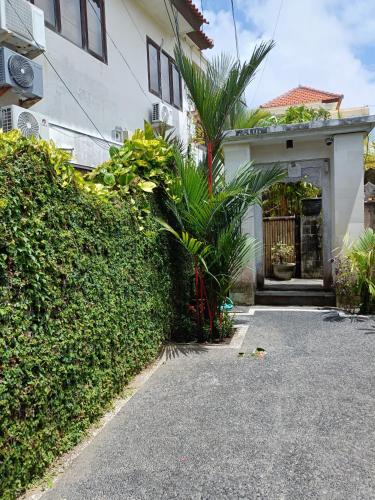 a house with a gate and a driveway at Ngetis Home Stay in Sanur