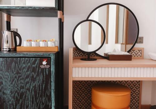 un miroir sur une étagère avec une table dans l'établissement The Lantern Resorts Patong - SHA Extra Plus, à Patong Beach