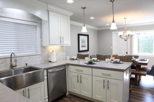 a kitchen with white cabinets and a stainless steel sink at Destination #39 in Orange