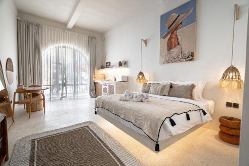 a bedroom with a large bed with a painting on the wall at Maison Boheme Modern Apartment & Villa with Pool in Sanur in Sanur