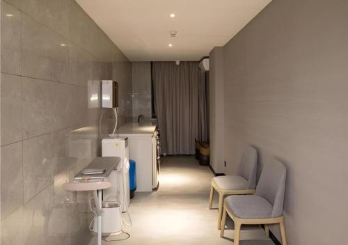 a bathroom with two chairs and a sink in a room at Echarm Hotel Guilin Railway Station the MixC in Guilin