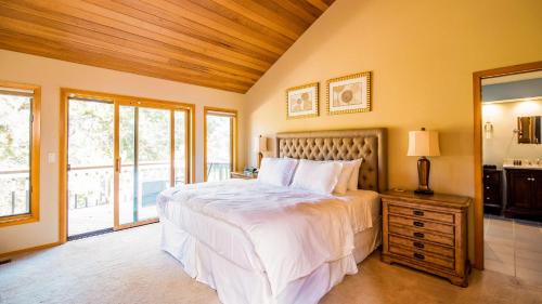 サンリヴァーにあるSunriver by AvantStay Cozy Mountain Home w Indoor Pool and Hot Tubの大きな白いベッドと窓のある寝室