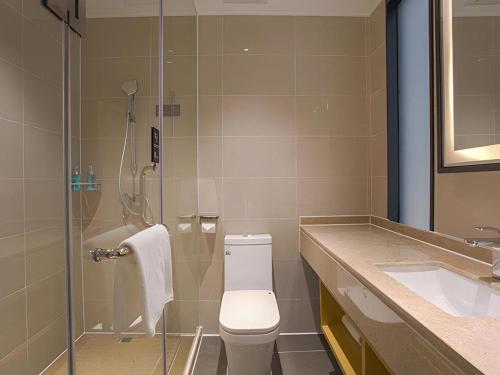 a bathroom with a shower and a toilet and a sink at City Comfort Inn Nanning Huanan City in Nanning