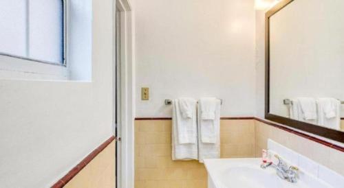 a bathroom with a sink and a mirror and towels at OYO Gateway Motel Las Vegas North Strip/Fremont St. Area in Las Vegas