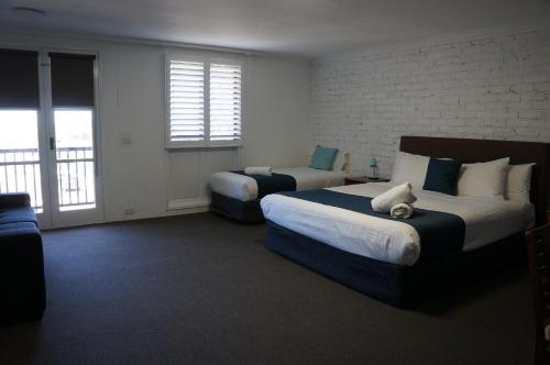 a hotel room with two beds and a balcony at Waves Motel and Apartments in Warrnambool