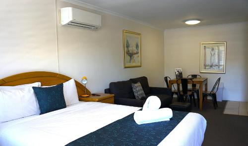 a bedroom with a bed and a living room at Waves Motel and Apartments in Warrnambool