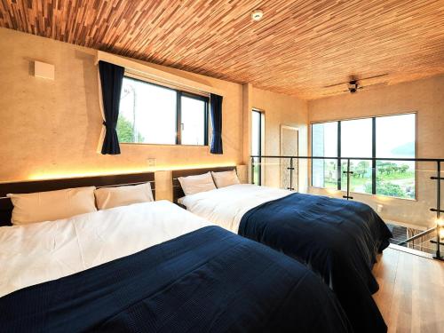two beds in a room with two windows at Rakuten STAY VILLA Lake Yamanakako 105 in Yamanakako