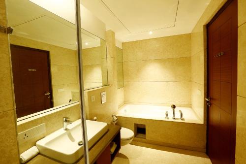 a bathroom with a sink and a toilet and a tub at Park Blu in Sonīpat