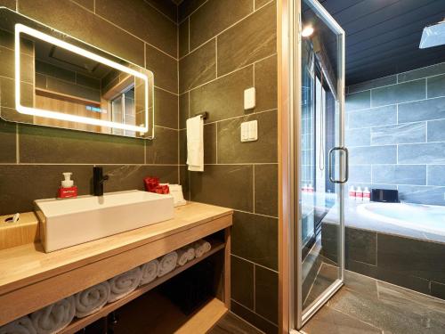 a bathroom with a sink and a mirror and a tub at Rakuten STAY VILLA Lake Yamanakako 104 Pets allowed with dog run in Yamanakako