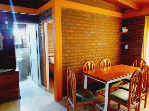 una sala da pranzo con tavolo e sedie in legno di Cabañas Yarel ad Alpa Corral