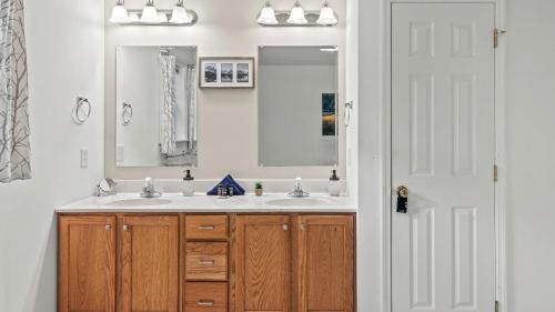a bathroom with two sinks and a mirror at Alpine Serenity by AvantStay Beach Lake Access Theater Deck Playroom in Albrightsville