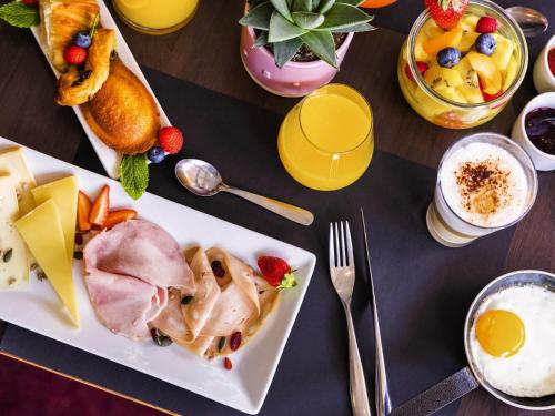 una mesa cubierta con un plato de comida y bebida en Mercure Tours Nord, en Tours