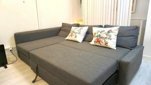 - un canapé avec deux oreillers dans l'établissement Fresh And Cozy Little House 30km In Täby, à Stockholm