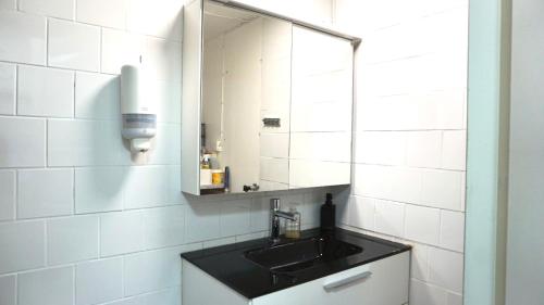 une salle de bain avec un lavabo et un miroir dans l'établissement Fresh And Cozy Little House 30km In Täby, à Stockholm