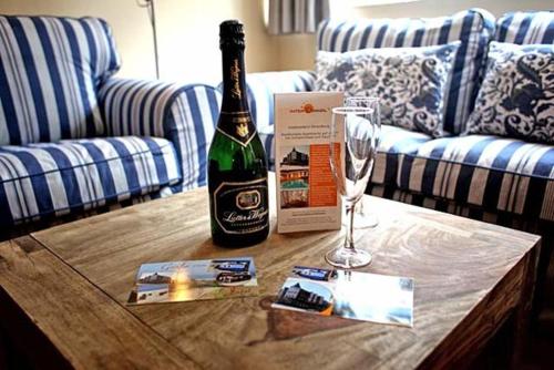 eine Flasche Champagner und ein Glas Wein auf dem Tisch in der Unterkunft Inselresidenz Strandburg Juist - Wohnung 106 (Ref. 50958) in Juist