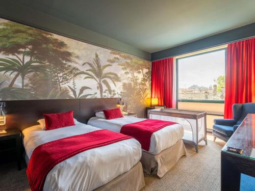 Una habitación de hotel con dos camas y una gran ventana. en Mercure Bordeaux Chateau Chartrons, en Burdeos