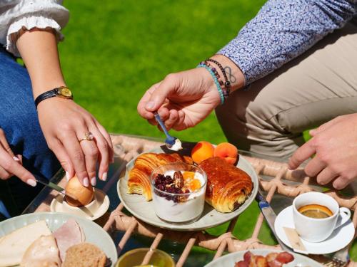 a group of people sitting around a table with a plate of food at Mercure Bordeaux Chateau Chartrons in Bordeaux
