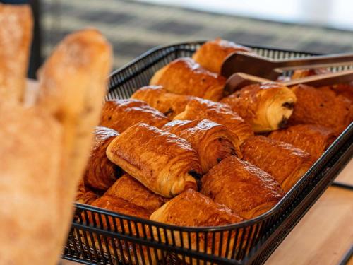 a basket of bread and pastries on a table at Mercure Bordeaux Chateau Chartrons in Bordeaux