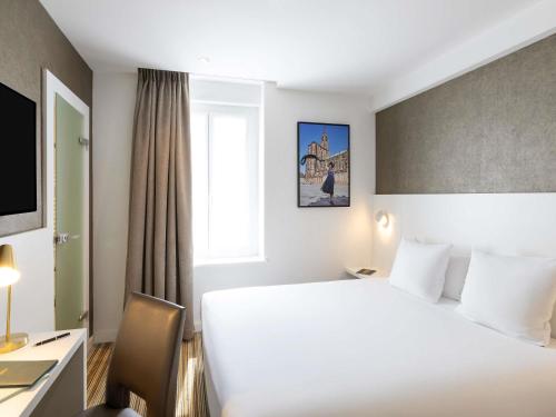 Un pat sau paturi într-o cameră la Mercure Strasbourg Centre Petite France