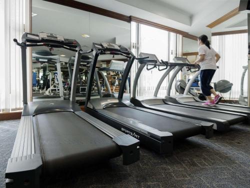 a woman running on a treadmill in a gym at The Heritage Grand Khon Kaen Hotel and Convention in Khon Kaen