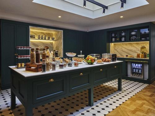 a kitchen with a large island with food on it at Mercure Versailles Chateau in Versailles