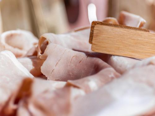 een stuk vlees met een houten spatel bij Mercure Reggio Emilia Centro Astoria in Reggio Emilia