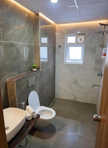 a bathroom with a toilet and a sink at Broadway Inn in Mysore