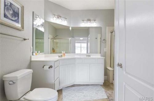 Un baño blanco con inodoro y lavabo. en 3BD 3BA Gated Condo LakeFront Lake Ozark, MO Isla Del Sol 4 M from Dam, en Rocky Mount