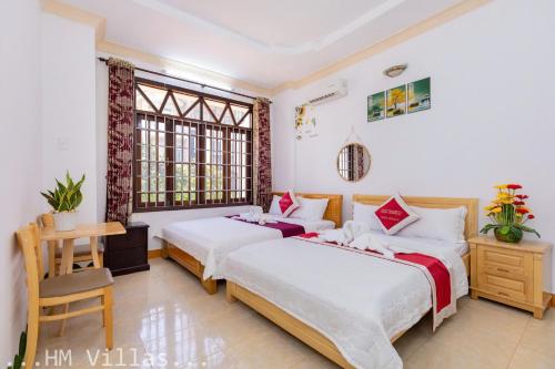 two beds in a room with two windows at Villages Hồ Bơi Gần Bãi Sau Khu Quảng Trường in Vung Tau
