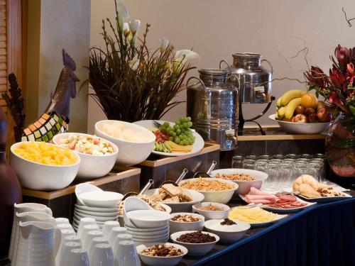a buffet with bowls and plates of food on a table at Mercure Queenstown Resort in Queenstown