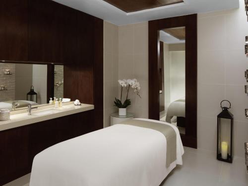 a bedroom with a white bed and a sink at Pullman Dubai Creek City Centre in Dubai