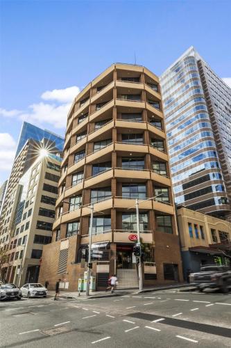 a tall building on a city street with buildings at Metro Apartments on Darling Harbour in Sydney