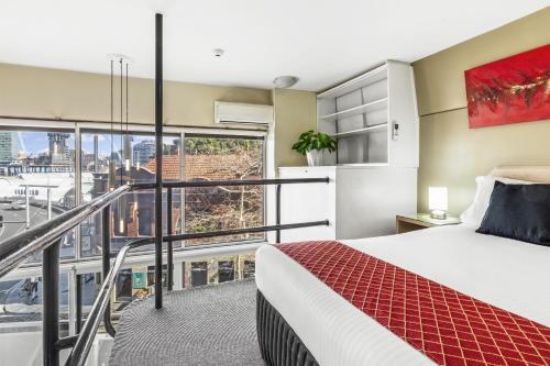 a bedroom with a bed and a balcony at Metro Apartments on Darling Harbour in Sydney