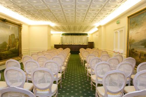an empty room with white chairs and a stage at Park Hotel Villaferrata in Grottaferrata