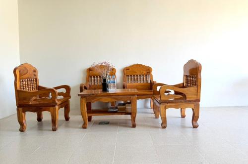 a wooden table with two chairs and a table with at KT Hotel Airport in Nai Yang Beach