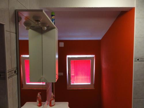uma casa de banho com um espelho e paredes vermelhas em Apartment Ivica em Vir