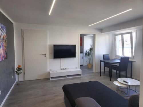 a living room with a couch and a table and a television at Bei Pina - Business apartment nahe Düsseldorf in Solingen