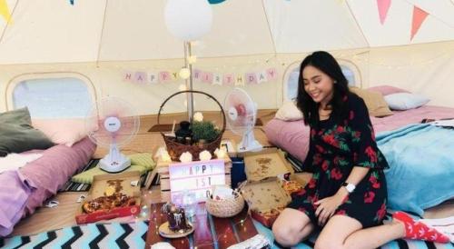 シンガポールにあるGlamping kaki singapore-Standard medium bell tentのテントの中で床に座っている女性