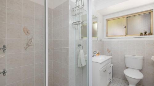a bathroom with a shower and a toilet and a sink at 2-5 The Meridian, Corlette in Corlette