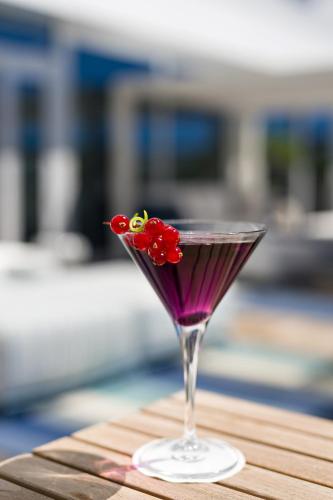 a martini glass with a red flower on a table at Golden Tulip Marseille Euromed in Marseille